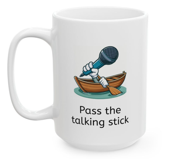 White ceramic coffee mug with two arms in a rowboat and one hand is holding an oar and the other is holding a large microphone and the corporate jargon phrase "pass the talking stick" is written below the image