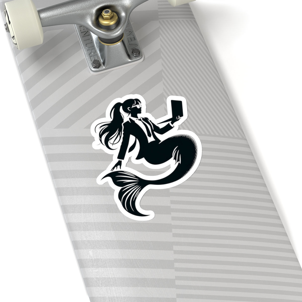 Corporate Mermaid Kiss-cut sticker on the bottom of a skateboard
The corporate mermaid logo is a black and white design of a mermaid in a suit, wearing glasses, with hair in a ponytail, holding an open laptop