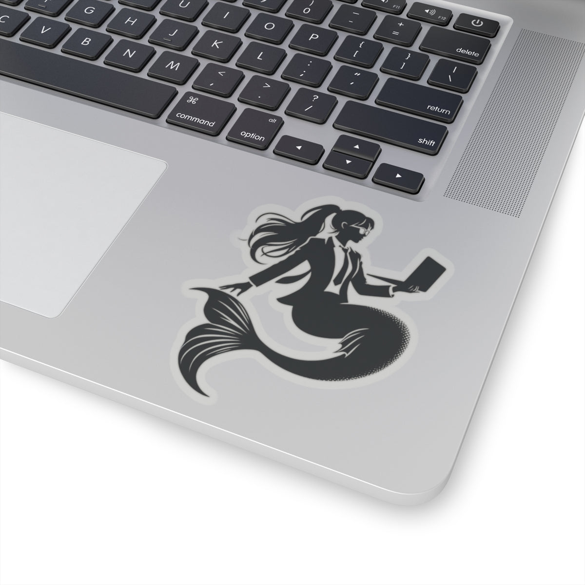 Corporate Mermaid Kiss-cut sticker on a laptop
The corporate mermaid logo is a black and white design of a mermaid in a suit, wearing glasses, with hair in a ponytail, holding an open laptop