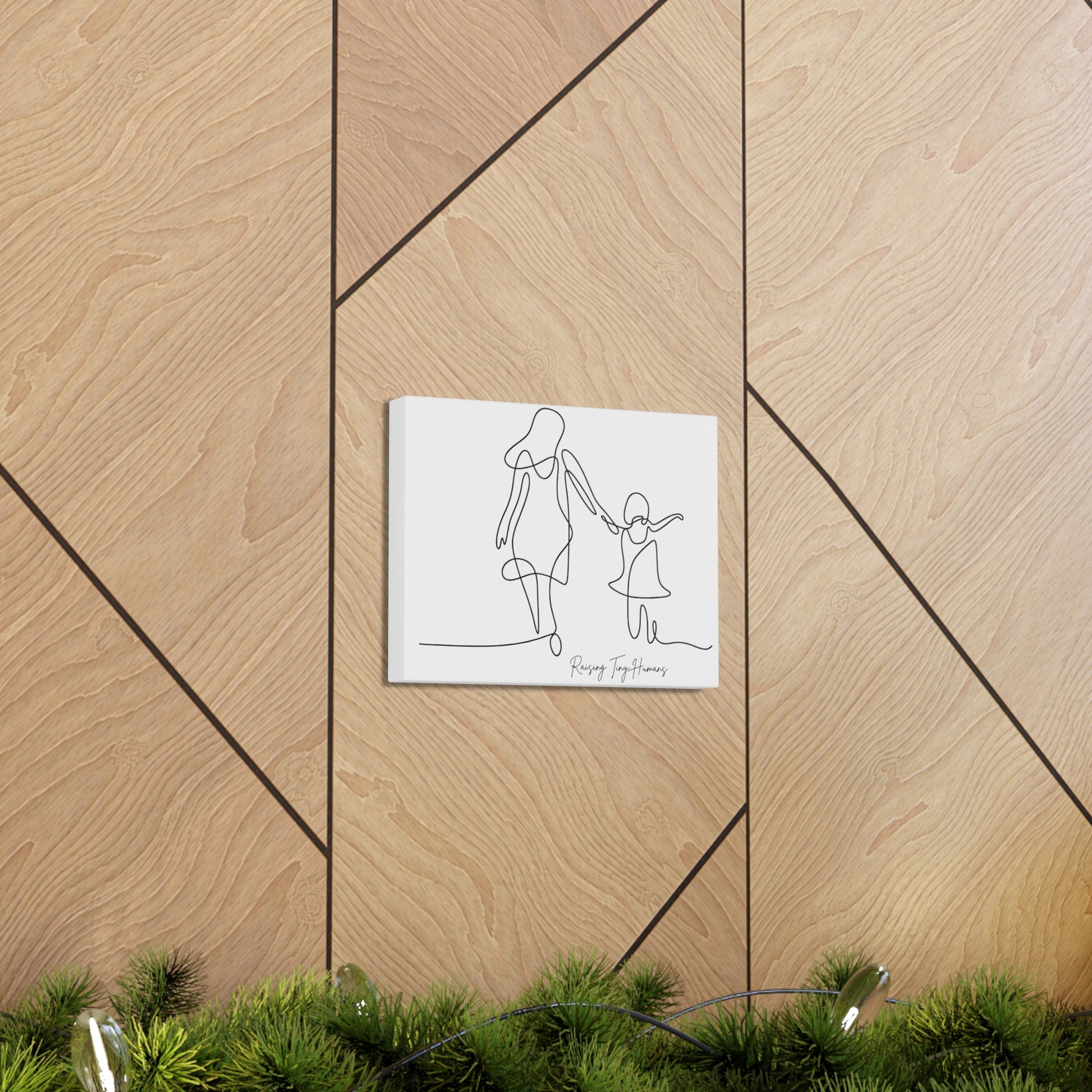 Raising Tiny Humans line drawing canvas wall decor featuring a mom and daughter holding hands.