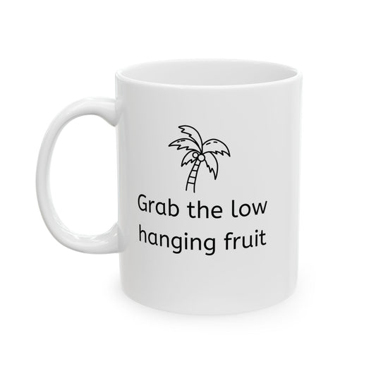 White ceramic corporate jargon mug with a coconut tree and the words "grab the low hanging fruit" on the front